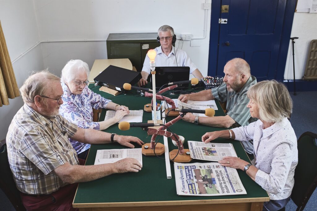 An editorial meeting at a Talking Newspaper encourages the concept of Education Education Education